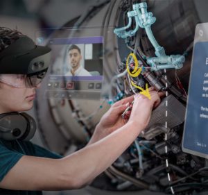 A mechanic wearing a HoloLens 2 device repairs equipment overlaid with 3D annotations and holographic windows showing a Teams call and step-by-step instructions