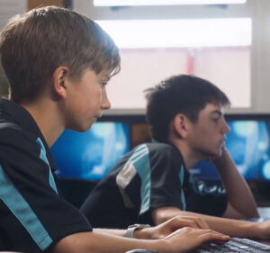 Two teenaged schoolboys working on computers