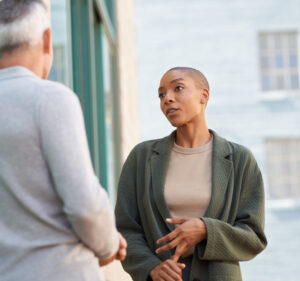 Woman talking with a colleague whose back is turned to the camera