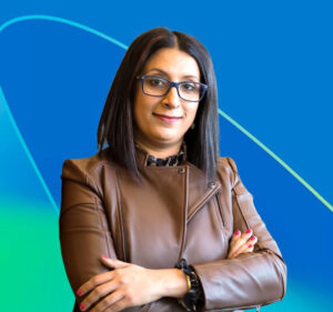 Woman with her arms folded in front of her as she stands against a blue and green background