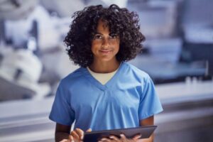 Young man in blue medical scrubs holding a mobile device