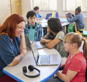 Teacher in a classroom helping one of her students