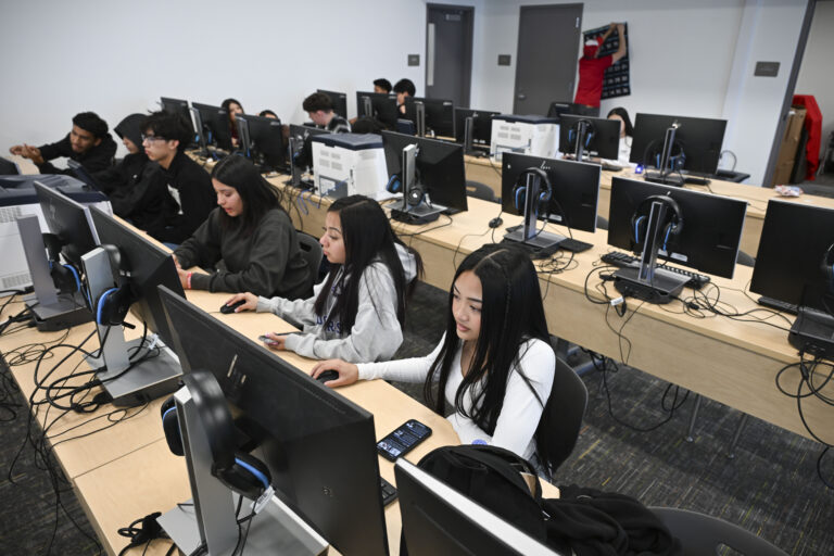 Rows of high school students working on computers in a classroom.