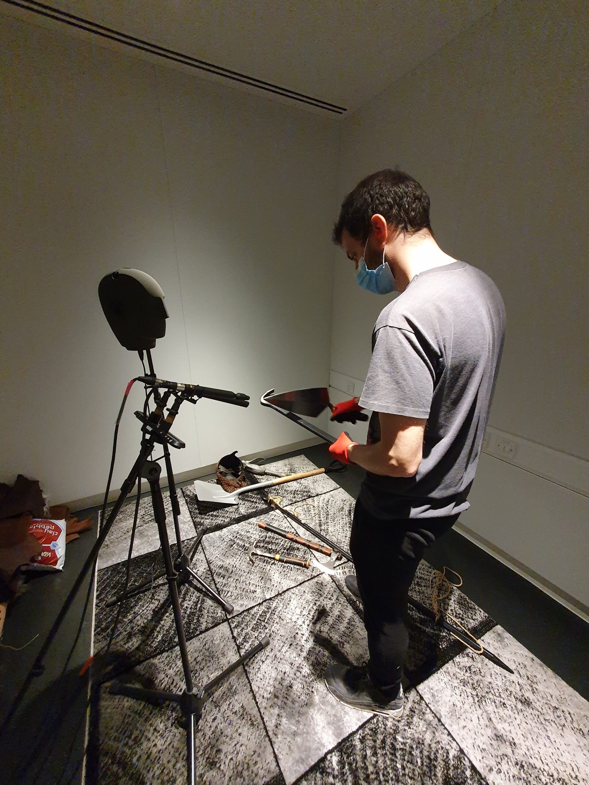 Man in studio next to microphone shaped like a human head