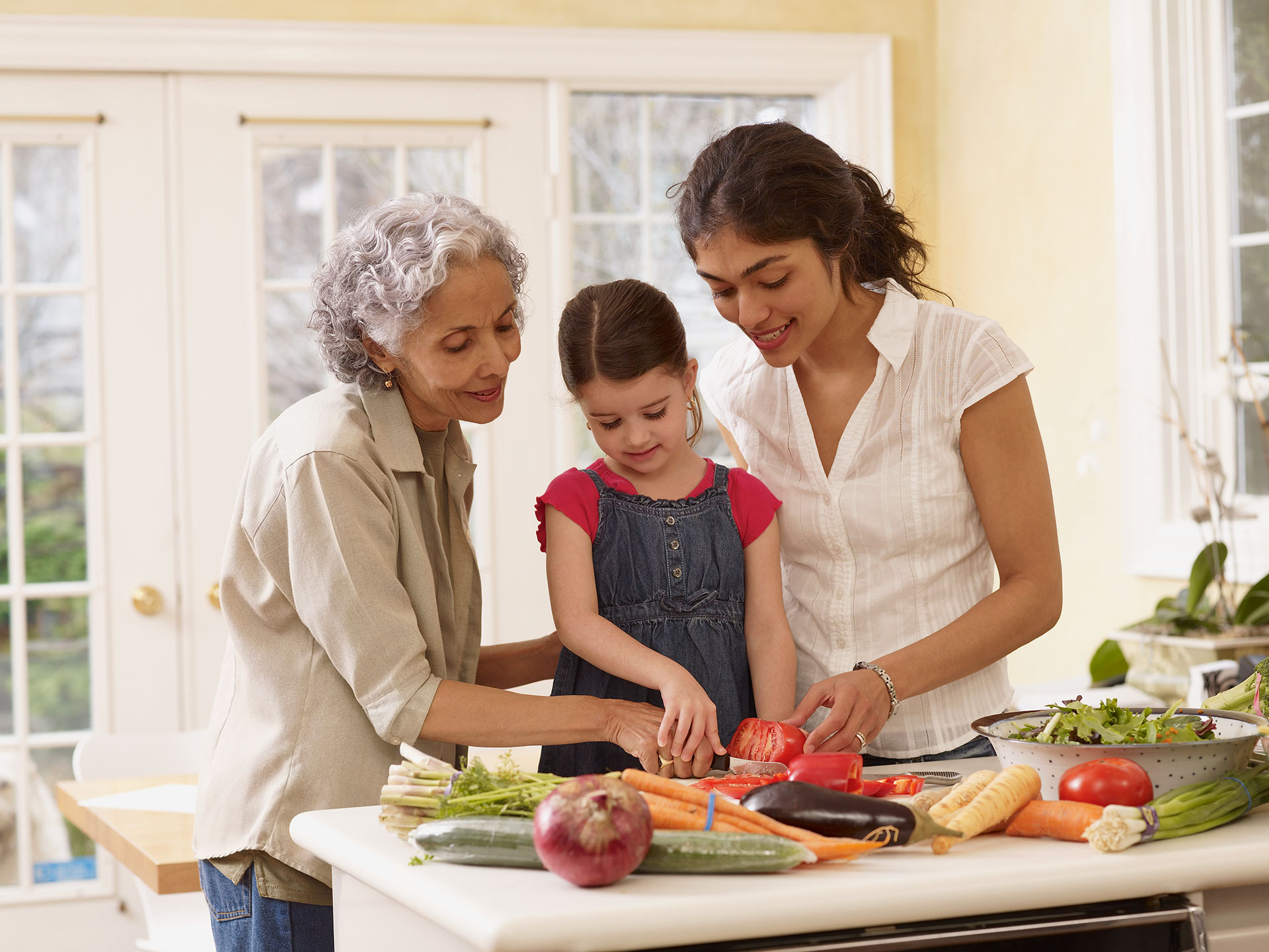 Two adults and a child making a meal together