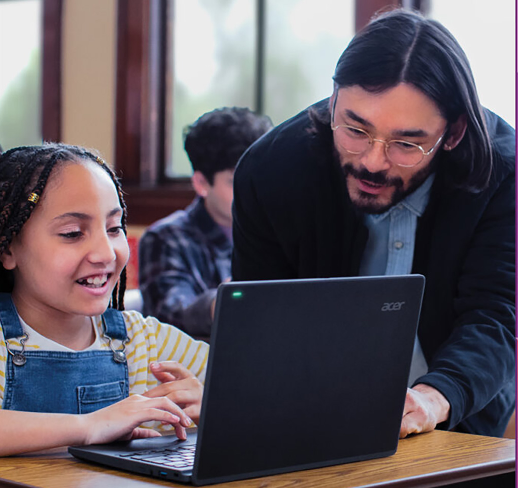 Teacher and student discussing what the student is working on at her laptop computer