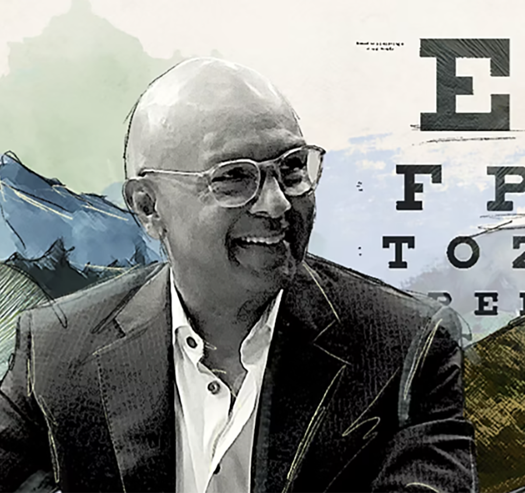 Smiling man next to an eye chart