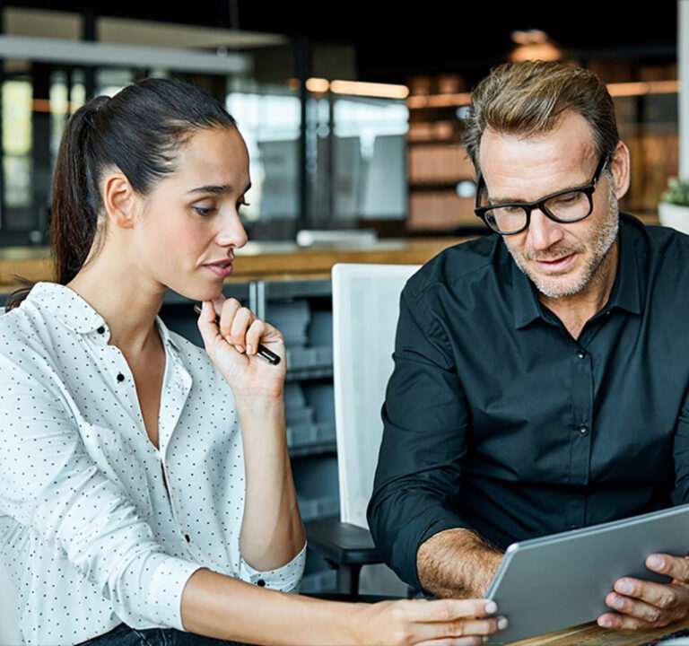 Woman and man discussing what they're seeing on a tablet computer.
