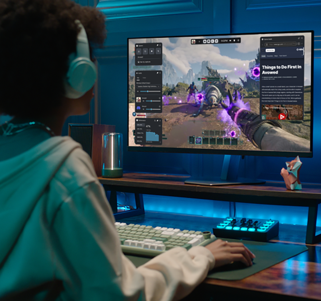 View from behind of a gamer wearing a headset and playing in front of a monitor.