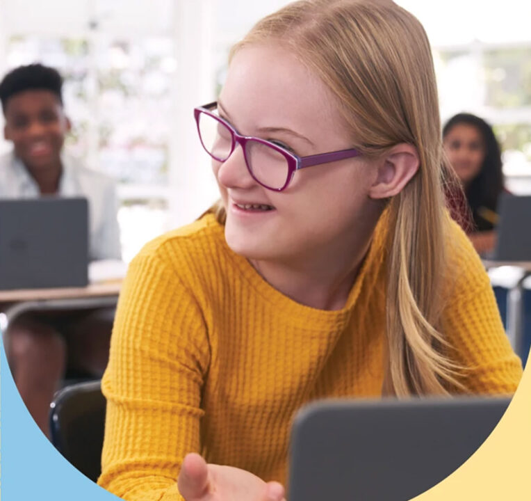 Girl in a classroom smiling.