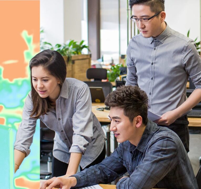 Three people working together at a computer