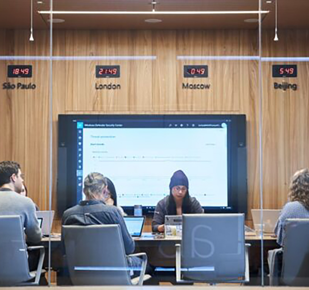 People seated around a large conference room desk.