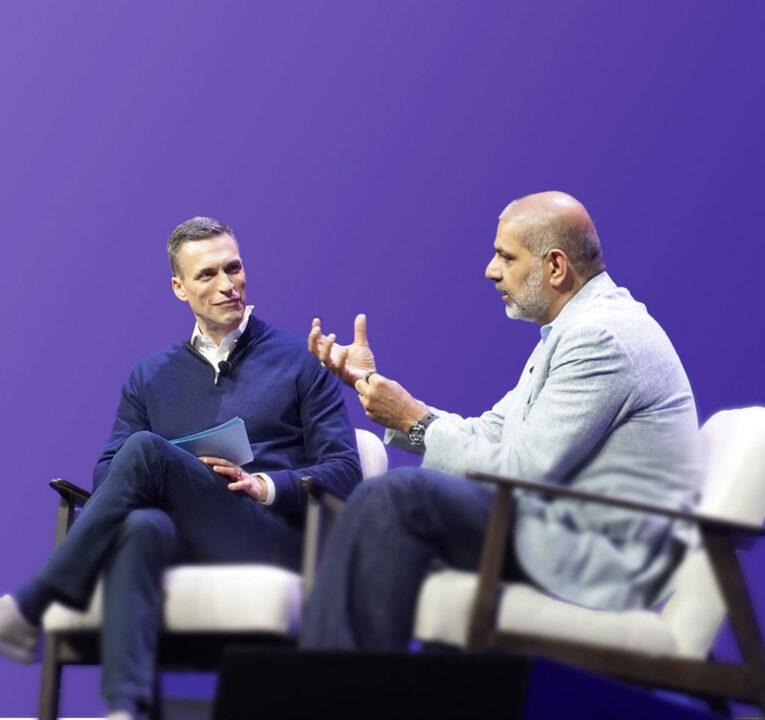 Two seated men having a discussion.